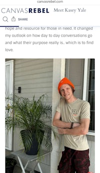 a man in an orange hat is standing in front of a plant